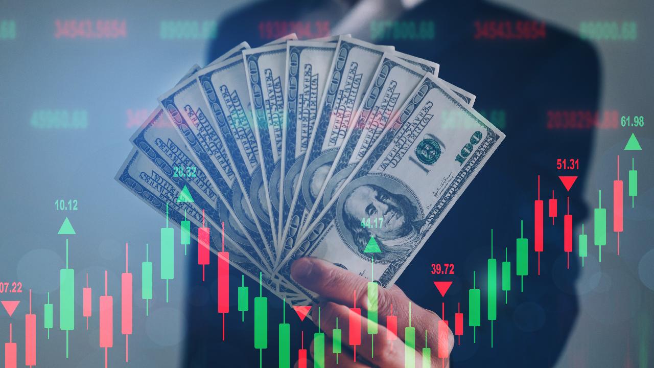  A businessman holding a stack of money in front of a candlestick chart with the text 'Take profit orders trading benefits'.